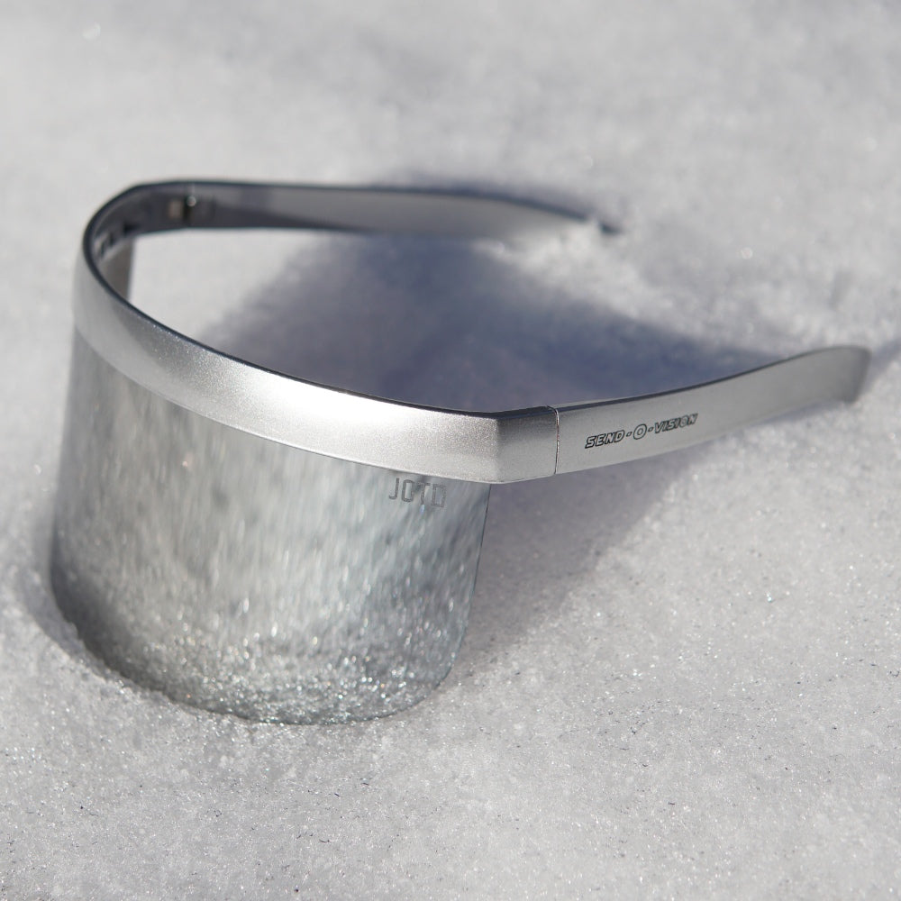 Jerry of the Dayglow Send-O-Vision 3.0 in silver, sitting in the snow. Funny ski and snowboard gifts, shirts, and apparel.