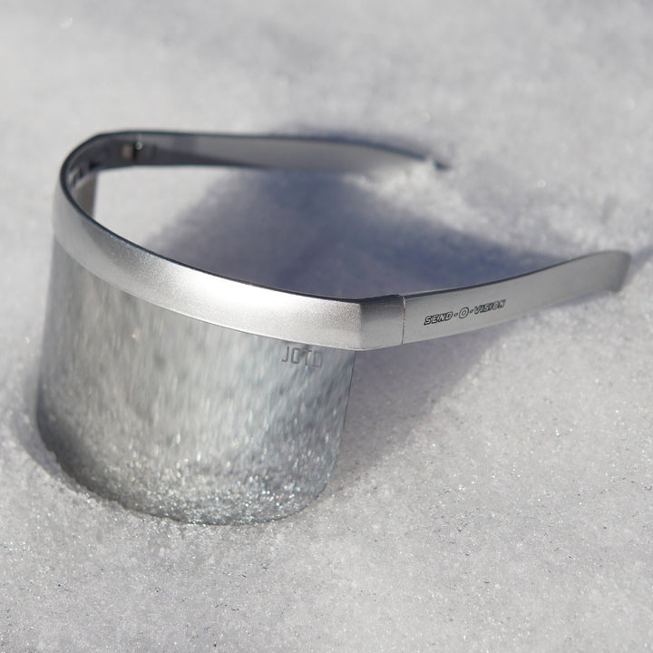 Jerry of the Dayglow Send-O-Vision 3.0 in silver, sitting in the snow. Funny ski and snowboard gifts, shirts, and apparel.