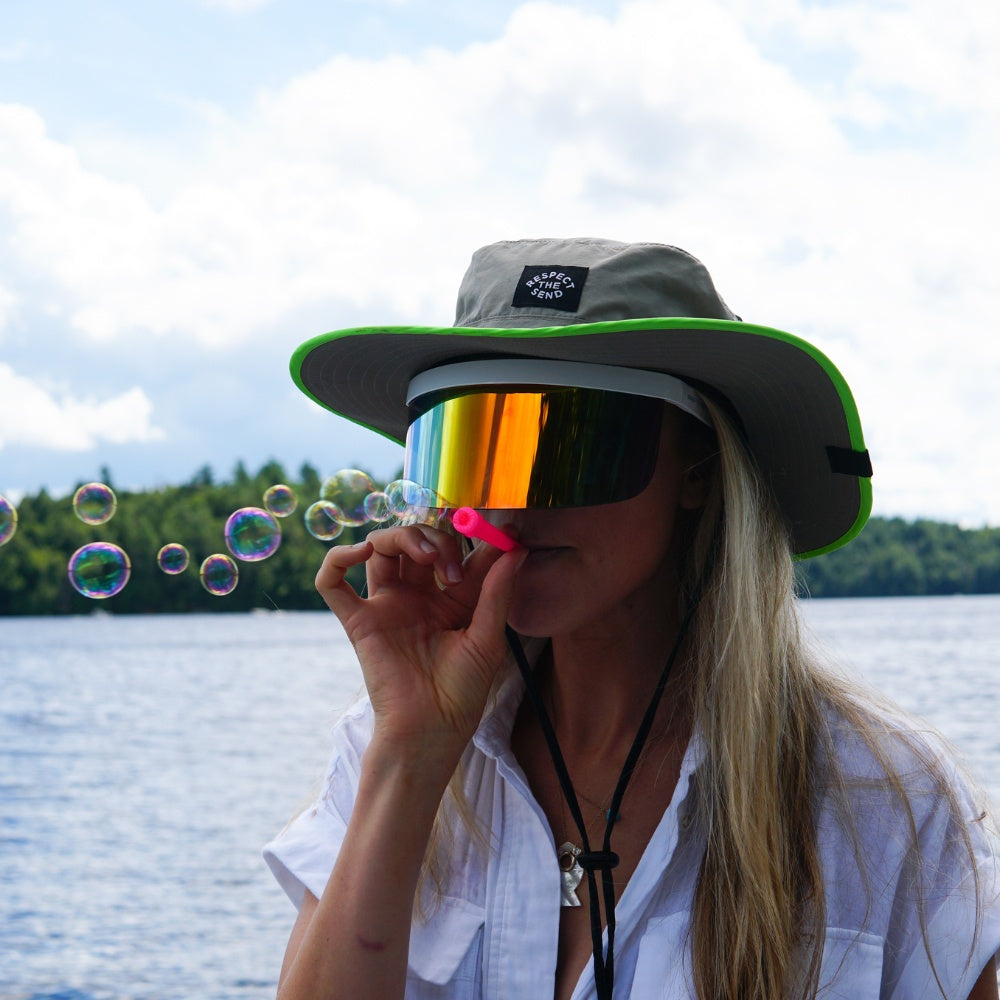 Jerry of the Dayglow Send-O-Vision 3.0 in yellow, woman wearing blowing bubbles. Funny ski and snowboard gifts, shirts, and apparel.