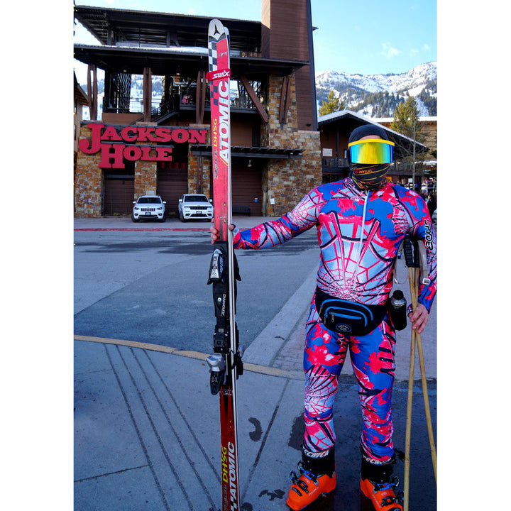 Jerry of the Dayglow Send-O-Vision 3.0 in yellow, man wearing with skis in Jackson Hole. Funny ski and snowboard gifts, shirts, and apparel