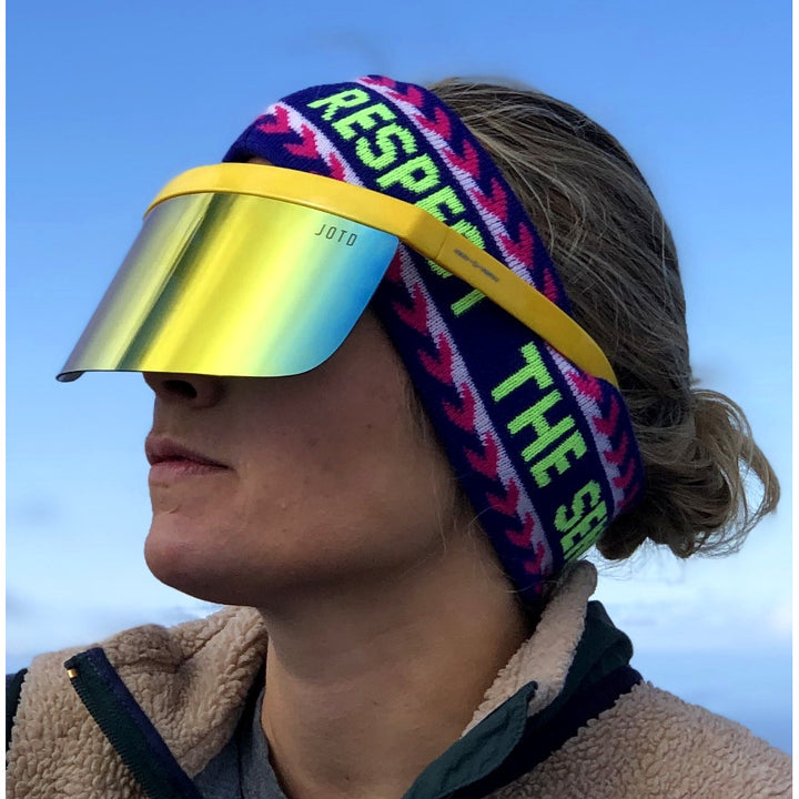Jerry of the Dayglow Send-O-Vision 3.0 in yellow, woman wearing outside with headband. Funny ski and snowboard gifts, shirts, and apparel.